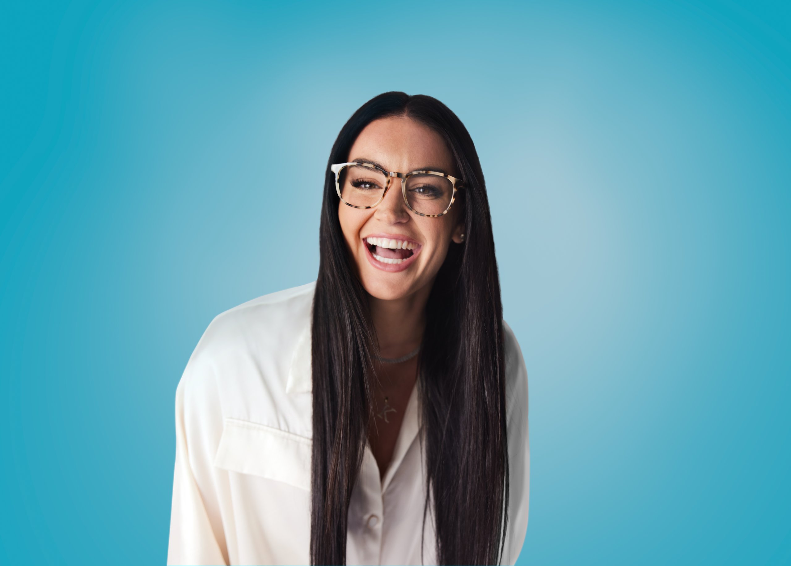 Woman wearing tortoiseshell glasses and a white blouse, smiling against a blue background.
