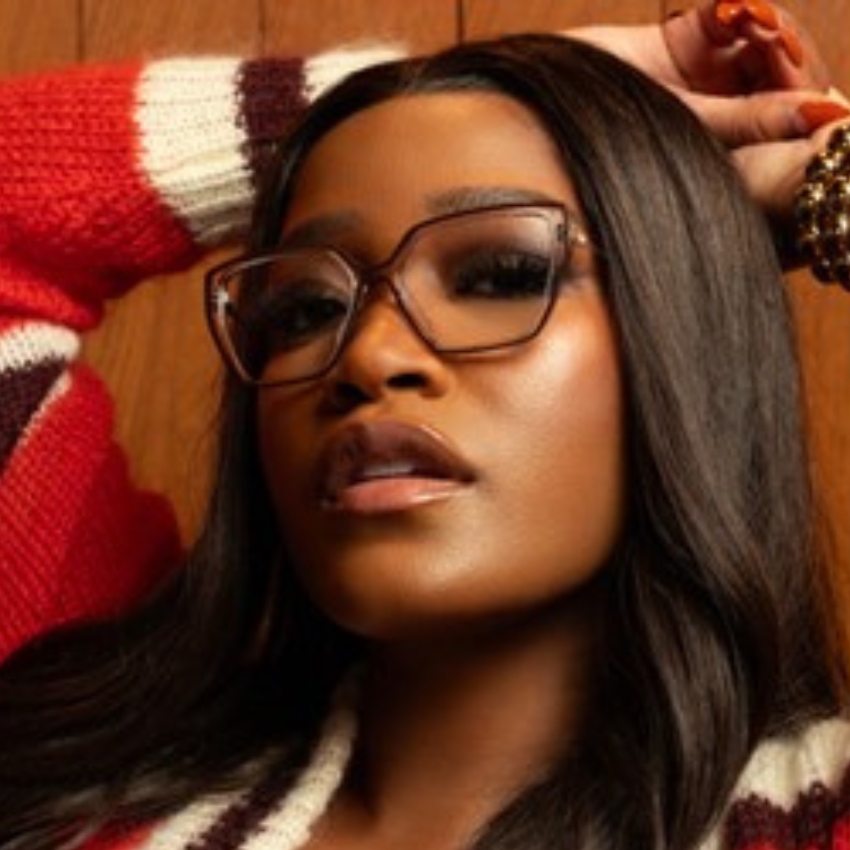 Woman wearing oversized, angular glasses with a tortoiseshell frame.