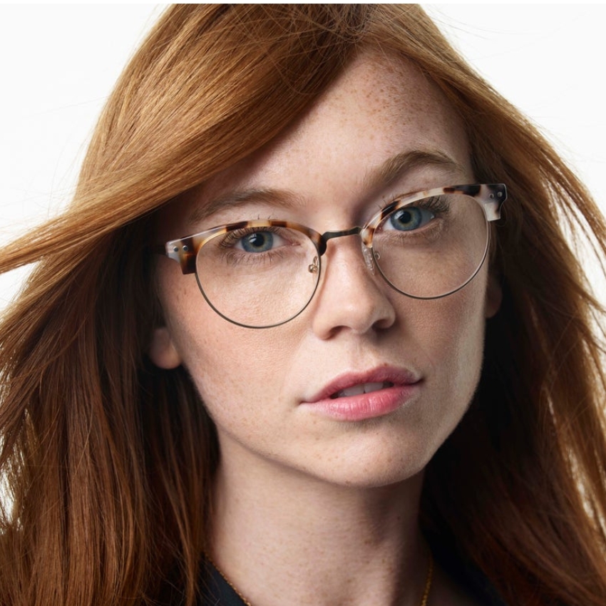 Woman wearing round tortoiseshell eyeglasses.