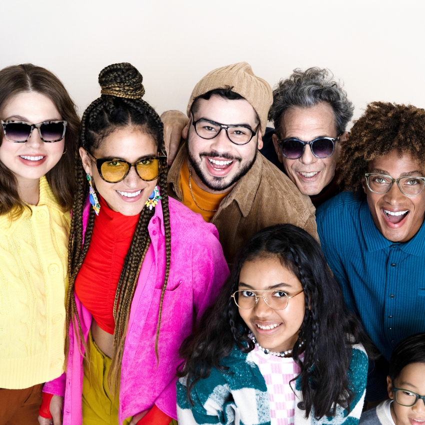 Group of people wearing various styles of glasses, smiling and posing together.