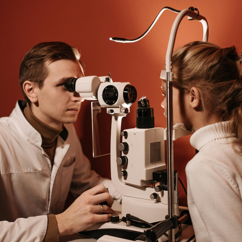 Optometrist using a slit lamp to examine a patient