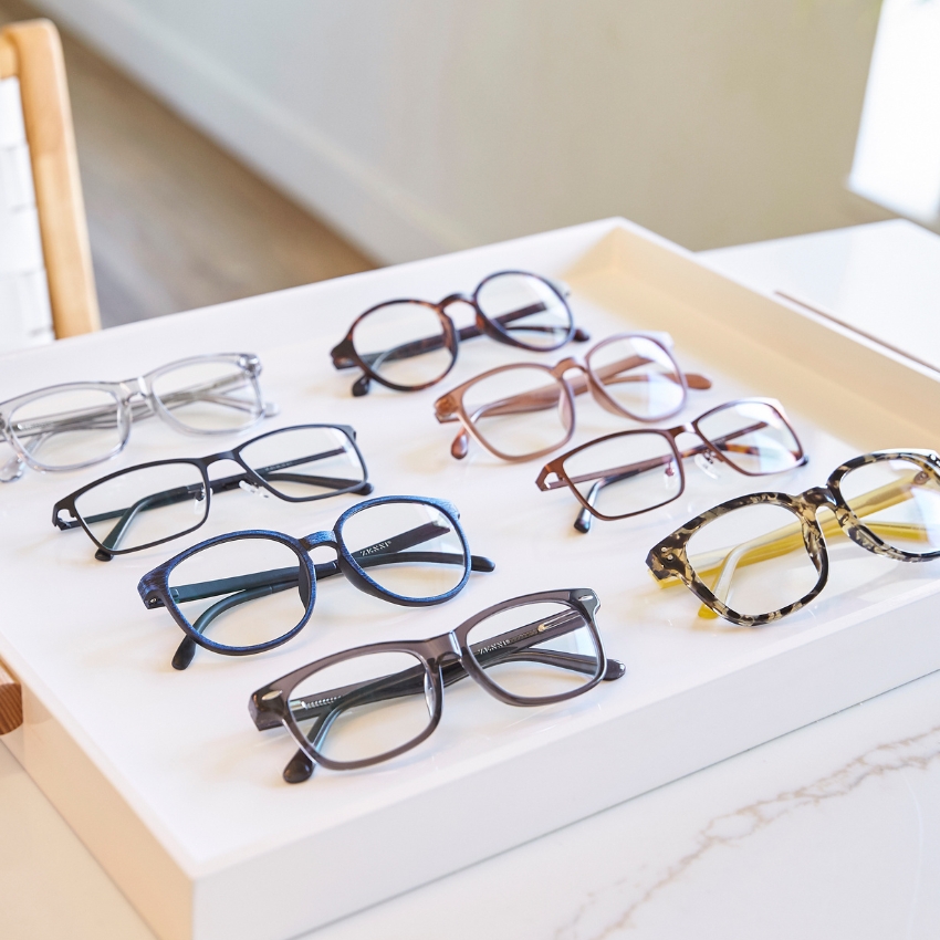 Various styles of eyeglasses displayed on a white tray.