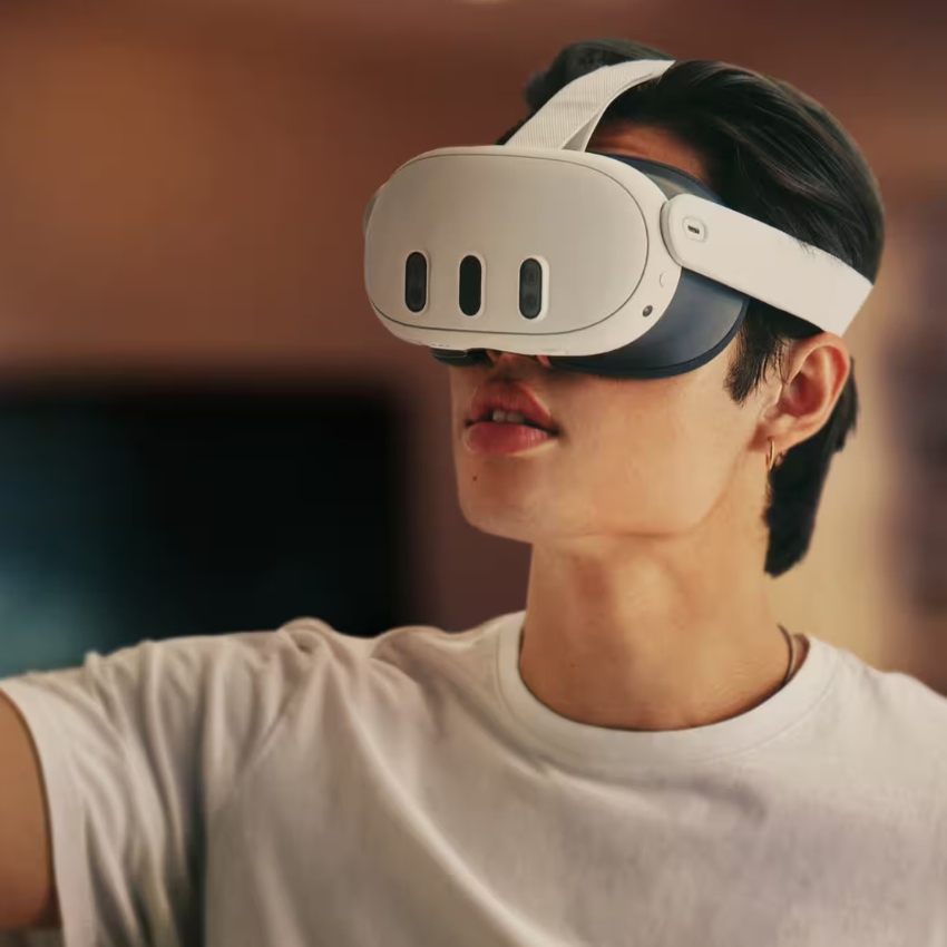 Person wearing a white virtual reality headset with three front cameras.