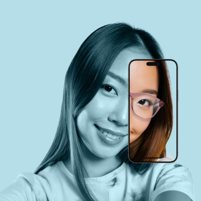 Woman holding a smartphone with part of her face visible on the phone screen, displaying a close-up of her eye with glasses.