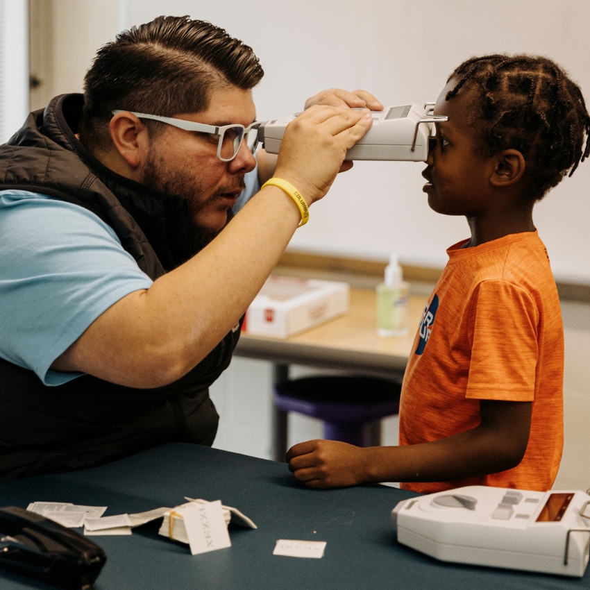 Vision screening device in use for an eye exam on a child.